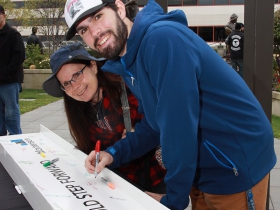 Celeste and Caleb Foster, MSOE University ME freshman, sign the beam that will become part of the new MSOE Dwight and Dian Diercks Computational Science Hall building under construction. Photo by Erol Reyal