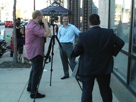 County Executive Chris Abele is interviewed outside Dream Bikes while aide Josh Zapfel (back to camera) looks on during Dream Street 2013.