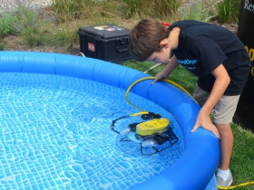 Child looks at an underwater robot from UWM School of Freshwater Sciences