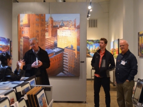 People surrounded by Hal Koenig's Urban Landscapes at Gallery Night and Day