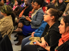 A full audience listens closely to political poetry.