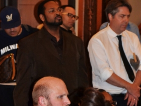 Aldermen Kovac, Hamilton, Murphy, and Perez watch their colleague perform a piece.