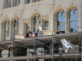 Construction workers putting finishing touches on the Iron Block Building.