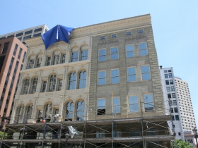 Construction workers putting finishing touches on the Iron Block Building.