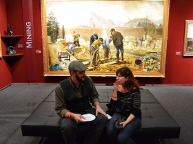 Guests were free to enjoy their locally filled plates in the company of grand paintings portraying post agricultural human evolution