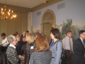 Linda Mellowes (l) faces Journal Sentinel publisher and new downtown resident Betsy Brenner (r) while real estate reporter Tom Daykin heads past the decorative wallpaper so reminiscent of the Jean Zuber et Cie hangings in the White House Diplomatic Reception Room. [Photograph taken Monday, January 13th, 2014 by Michael Horne.]