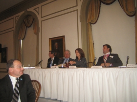 Panelists Joe Ulrich of U.S. Bank (l) and developer Mark Irgens join Sandy Botcher of NM on the dais as Rick Barrett buttons his jacket. Photo taken Monday, January 13th, 2014 by Michael Horne.