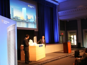 CEO John Schlifske and Jon Pickard look at the building model.