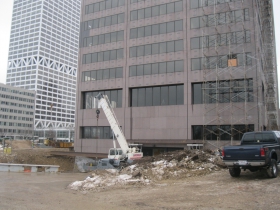 The U.S. Bank Center is seen behind the deconstruction.