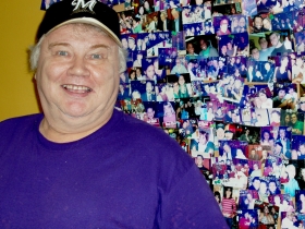 James Stocks backed by images of Real Chili regulars.  Photo by Peggy Schulz.