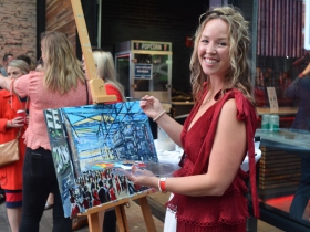 Katie Geis paints a picture live at Dinner in the Alley 2019