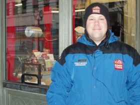 Justin Miller awaits visitors to the Visit Milwaukee information booth at 214 W. Wisconsin Ave., which was once a movie theatre, and now is staffed by the Public Service Ambassadors. Photo by Peggy Schulz