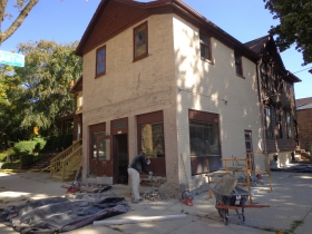 1600 N. Jackson Street, the former Dentice Sausage Market is being remodeled. The worker is chipping away brick from the very old building. The brick itself had been re-used and showed possible signs of a fire to a previous structure. There is an ancient dirt cellar exposed right now.