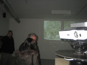 The projector (l) immerses the gallery attendees into a domestic scene that wraps around the room and undergoes subtle changes.