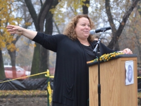 Michele Bria, the CEO of Journey House, points to the large pile of dirt that will soon be an NFL grade practice field