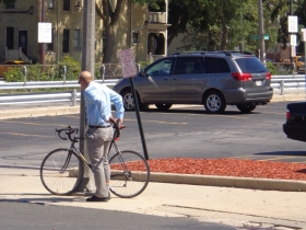 Ald. Kovac locking his bike up on a pole.