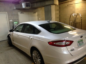 An electric car charging in the garage.