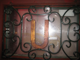 Sturdy ironwork on the front door includes the tavern's initial, readable from inside and out.