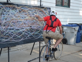 Riverwest 24 Cyclist Leaving his Mark on the Art Board at the Milwaukee Rrt Collective Bonus Checkpoint