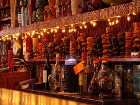 Small tiki statues decor behind the bar.