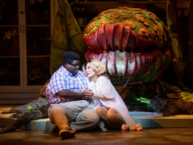 (l. to r.) Kevin James Sievert (Seymour) and Ashley Oviedo (Audrey) in Skylight Music Theatre’s production of Little Shop of Horrors running November 19, 2021 - January 2, 2022. (Editor’s Note: Audrey II Puppeteer - Gabriella Ashlin. Audrey II Voice - Aaron Reese Boseman).