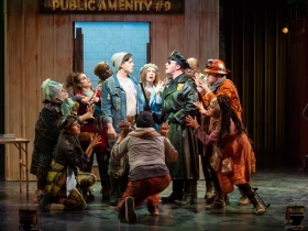 Lucas Pastrana, left center (Bobby Strong) and Rick Pendzich, right center (Officer Lockstock), perform with the cast in rehearsal for Skylight Music Theatre’s production of Urinetown, The Musical May 18 – June 10 on the Cabot Theatre stage.