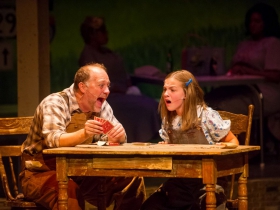 Foreground: Jeff Schaetzke (Father) and Kylee Hennes (Young Violet). Background: Cynthia Cobb (bus passenger) and Raven Dockery (bus passenger) in Skylight Music Theatre’s Violet