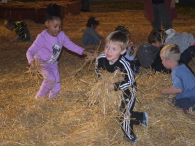 Children play in the straw at Harvest Fair 2019