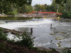 Anglers cast their lines downstream of the Kletzsch Dam in September 2023 as the fishway is constructed on the east bank beyond.