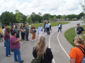 Delegates from a dozen U.S. cities tour Milwaukee's Kluge Elementary schoolyard on May 28, 2024 co-led by Justin Hegarty, executive director of the nonprofit Reflo, and Heather Dietzel, sustainability project manager for Milwaukee Public Schools. Many sought to learn from or emulate Milwaukee’s model for greening urban schoolyards and connecting outdoor learning and play.