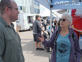 PhD student Nick Miller listens to Sturgeon Protector volunteer Anne Steinberg at Harbor Fest 2023