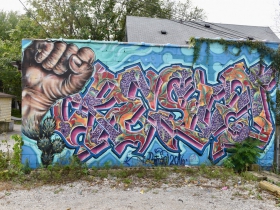 A mural spelling 'resist,' also by Ramiro Sandoval Argueta.