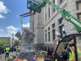 Workers install piece by Tony Tasset