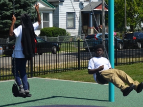Children swing at Columbia Playfield on the day of its reopening
