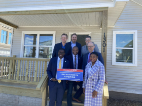 Local and federal officials pose with sign promoting President Joe Biden's Investing in America agenda. Photo by Graham Kilmer.