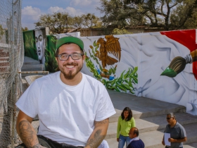 Chacho Lopez is all smiles as he sits in front of the completed mural.