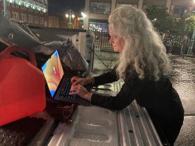 Heather Perkins works to project anti-Trump messages on building in Historic Third Ward