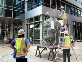 Workers install piece by Jim Dine
