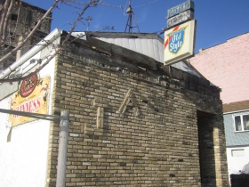 An Old Style sign hangs over the entrance to Just Art's.