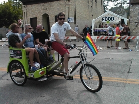 Joe Pabst and friends cruise through the Pride Parade aftermath on a chauffeured bicycle. It's the way to go for special occasions like this.